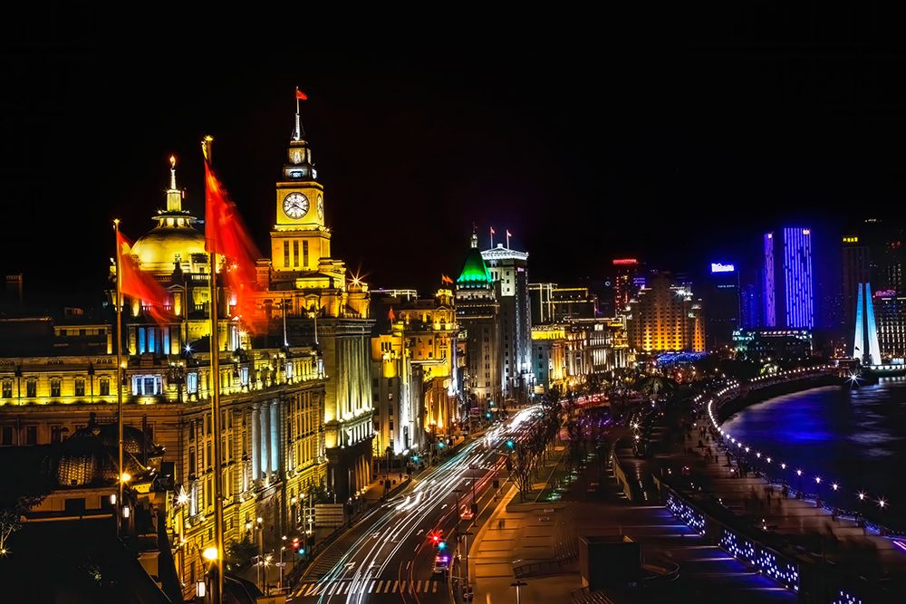 The Bund, old part of Shanghai at night with cars.